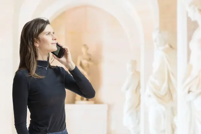Rondleider spreekt in de microfoon van een Orpheo Hybe in een museum