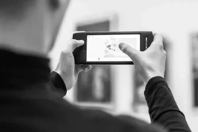 Bezoeker bekijkt een museumapp op zijn smartphone