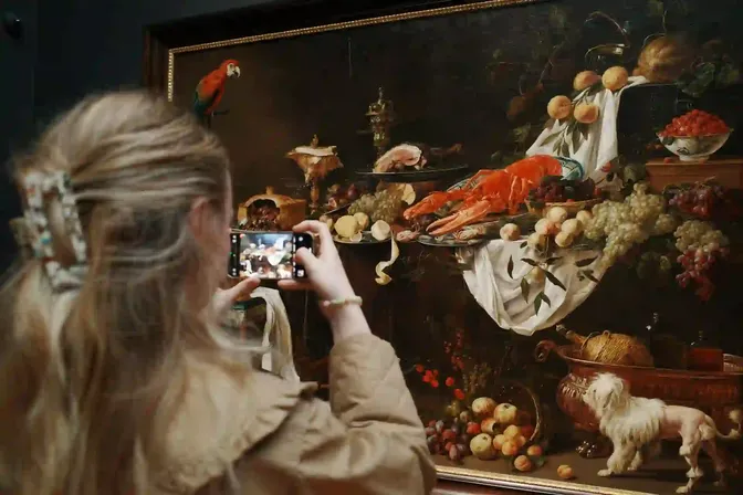 Bezoekster fotografeert een stilleven met haar smartphone in een museum